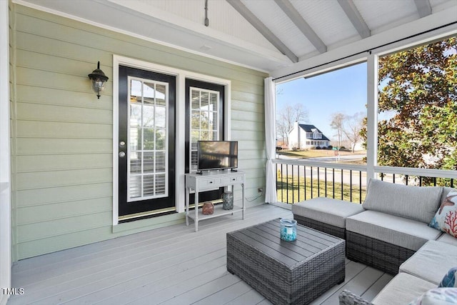 sunroom / solarium with plenty of natural light and lofted ceiling with beams