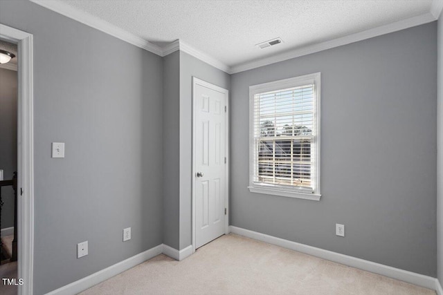 unfurnished bedroom with crown molding, light carpet, and a textured ceiling