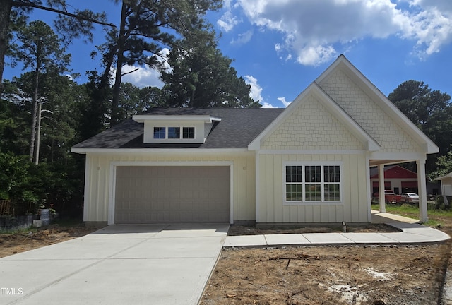 1203 Elizabeth Rd W, Wilson, NC 27896 - view of front of house featuring a garage, concrete driveway, board and batten siding, and a shingled roof