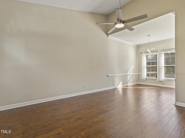 empty room with dark hardwood / wood-style flooring, ceiling fan with notable chandelier, crown molding, and a textured ceiling