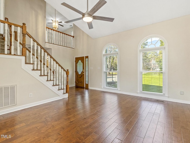 unfurnished living room with dark wood-type flooring, ceiling fan, and high vaulted ceiling