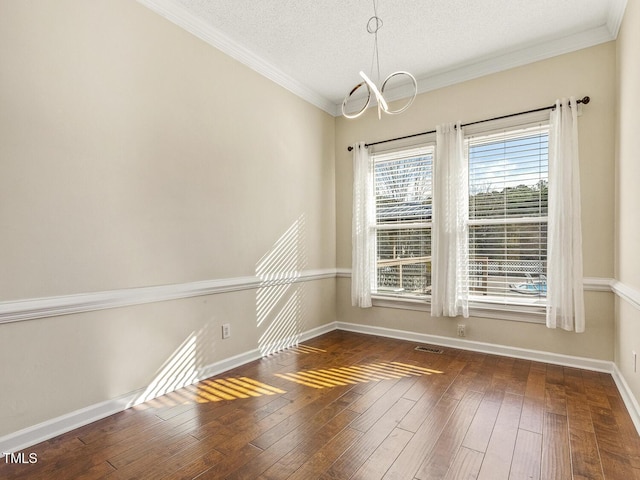 empty room with crown molding, dark hardwood / wood-style floors, a chandelier, and a textured ceiling