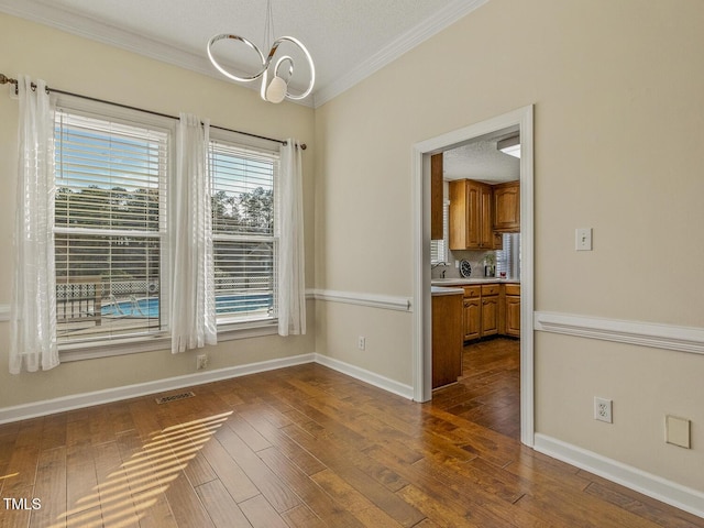 unfurnished dining area with crown molding, a chandelier, and dark hardwood / wood-style flooring