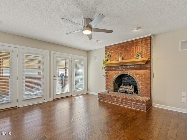 unfurnished living room with ceiling fan, dark wood-type flooring, a textured ceiling, and a fireplace