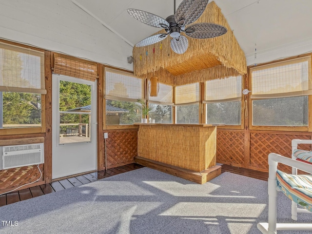 sunroom / solarium with ceiling fan, vaulted ceiling, and a wall unit AC