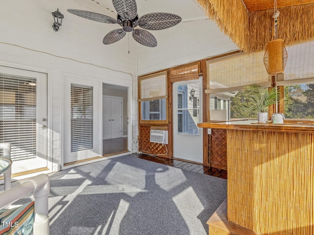 sunroom / solarium featuring ceiling fan and a wall unit AC