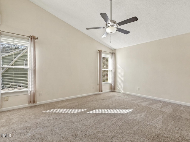 empty room with vaulted ceiling, carpet floors, ceiling fan, and a textured ceiling