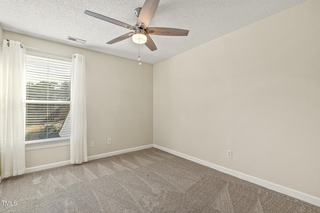 carpeted spare room featuring ceiling fan and a textured ceiling