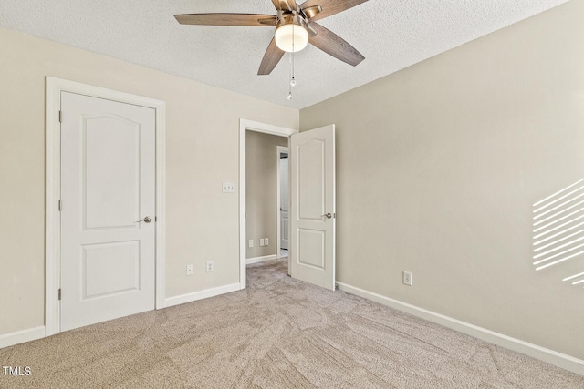 unfurnished bedroom featuring light carpet, ceiling fan, and a textured ceiling