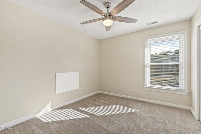 spare room featuring ceiling fan, carpet, and a textured ceiling