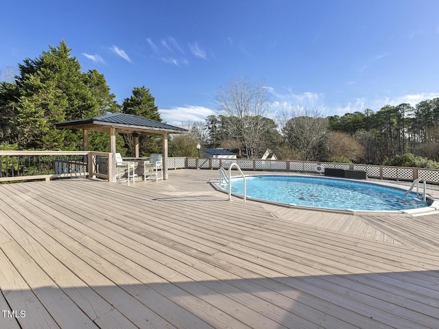 view of pool with a wooden deck and a gazebo