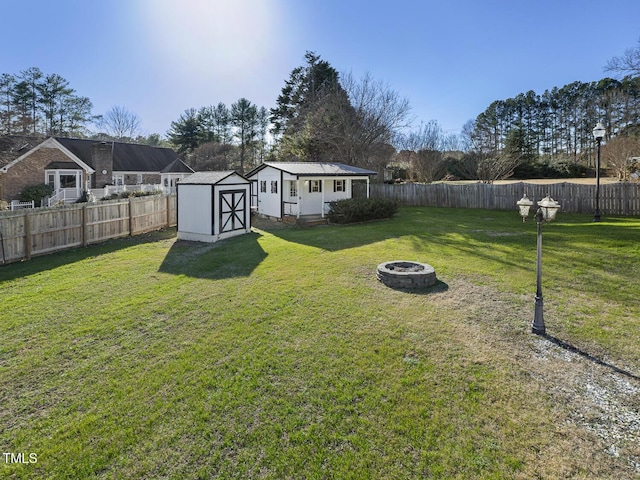 view of yard with a storage shed and an outdoor fire pit