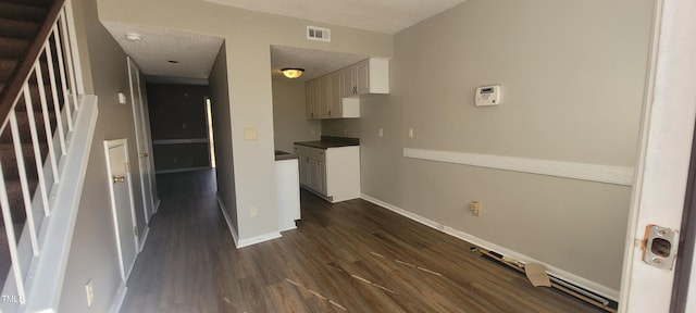 kitchen with dark wood-type flooring, a textured ceiling, and white cabinets