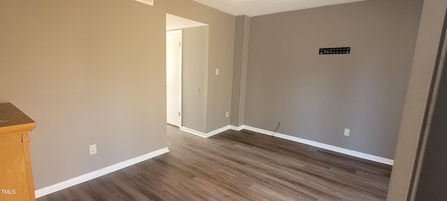 unfurnished room with dark wood-type flooring