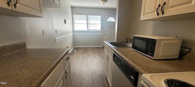 kitchen with sink, hardwood / wood-style flooring, and stainless steel dishwasher