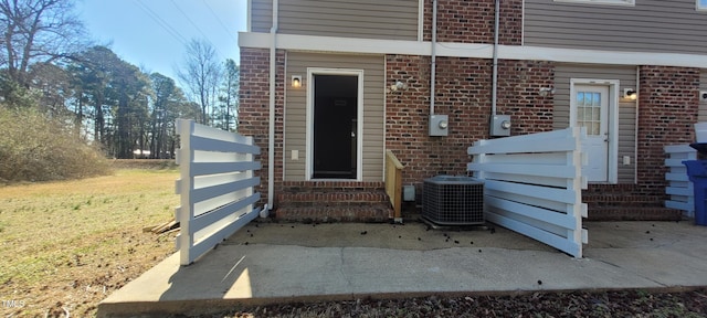 entrance to property with central AC unit and a patio