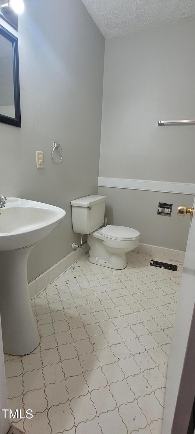 bathroom featuring toilet and a textured ceiling