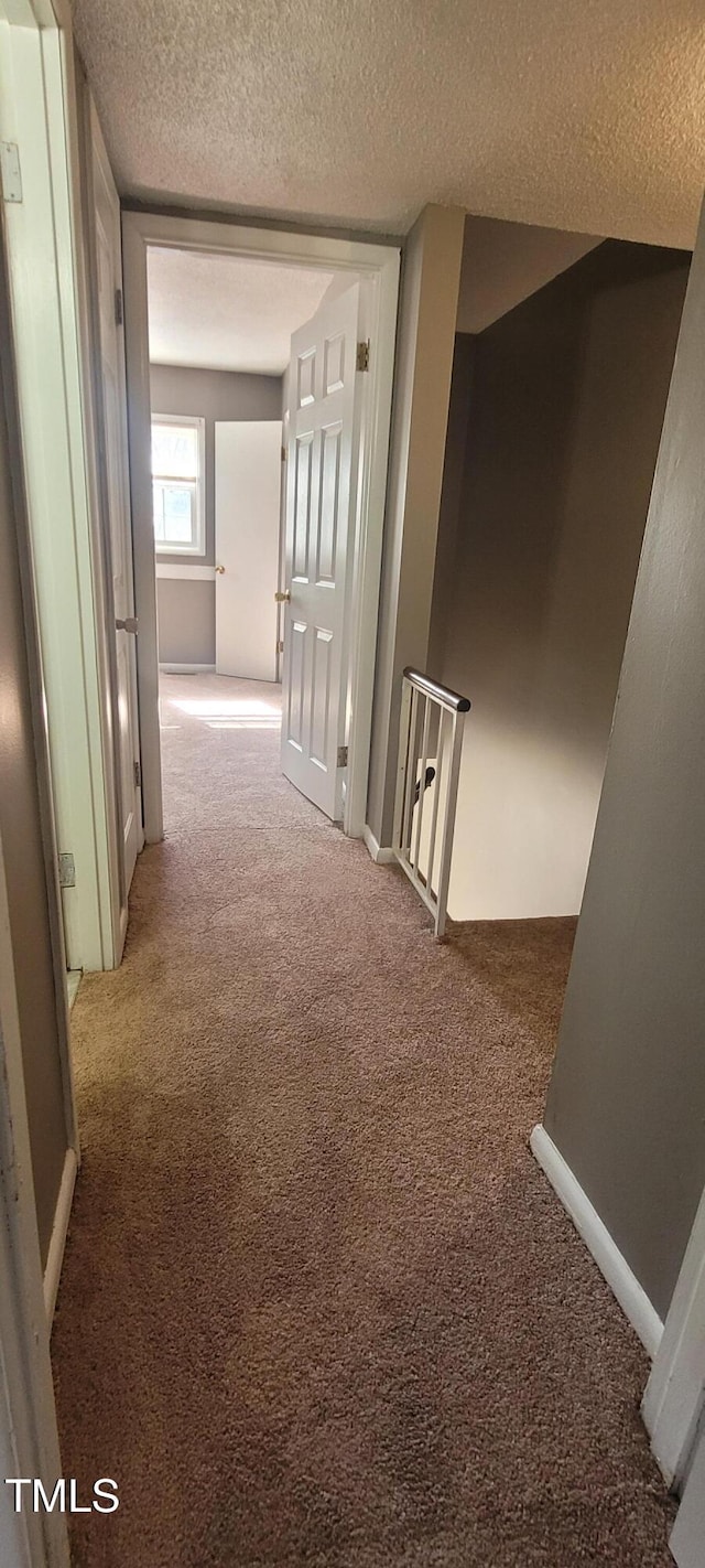 corridor featuring carpet floors and a textured ceiling