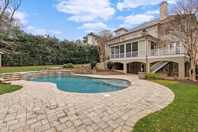 outdoor pool featuring a patio area, stairway, and a sunroom