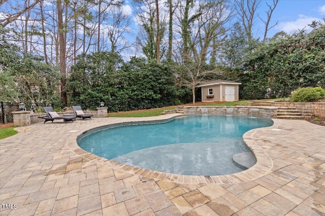 view of pool featuring an outbuilding, a fenced in pool, and a patio