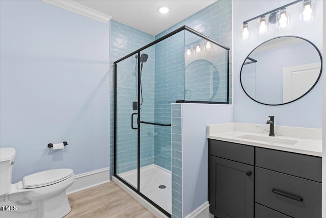 full bath featuring toilet, a shower stall, vanity, wood finished floors, and baseboards