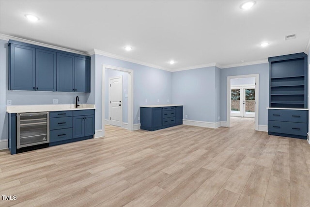 bar with visible vents, light wood-style flooring, wine cooler, a sink, and indoor wet bar