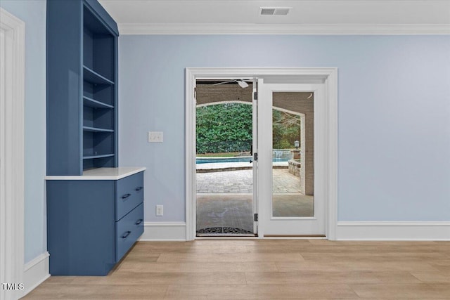 doorway to outside with baseboards, visible vents, built in features, ornamental molding, and light wood-style floors