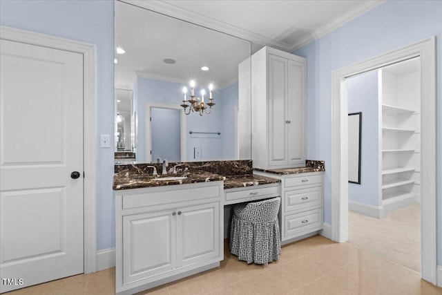 full bath with tile patterned flooring, vanity, baseboards, ornamental molding, and an inviting chandelier