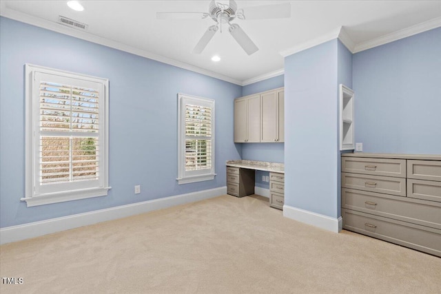 unfurnished bedroom featuring crown molding, light colored carpet, visible vents, built in study area, and baseboards