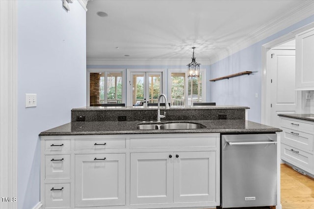 kitchen with dark stone counters, a sink, white cabinetry, ornamental molding, and dishwasher