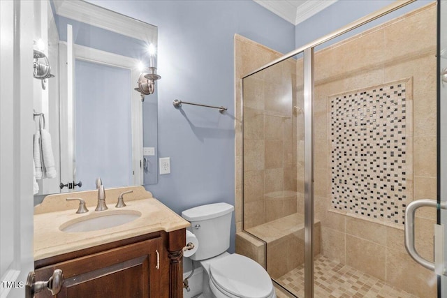 bathroom featuring ornamental molding, toilet, a shower stall, and vanity