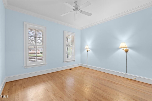 empty room featuring ornamental molding, a ceiling fan, baseboards, and wood finished floors