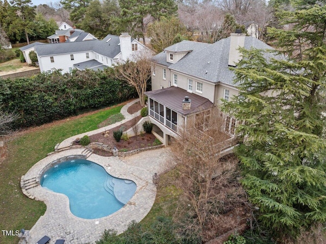 pool with a sunroom and a patio