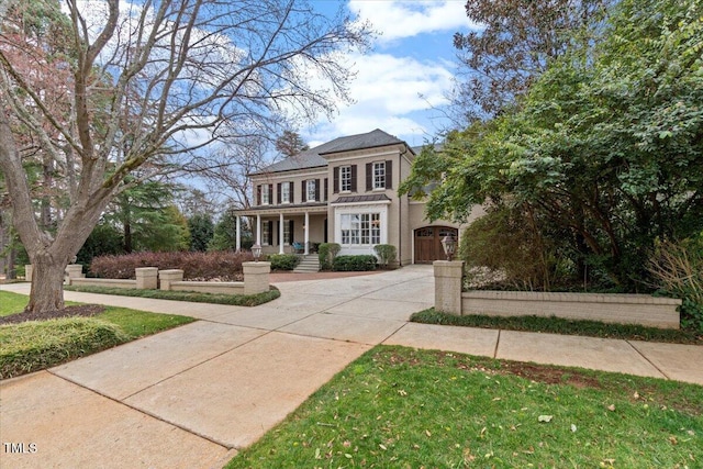 view of front of home with covered porch, driveway, and stucco siding