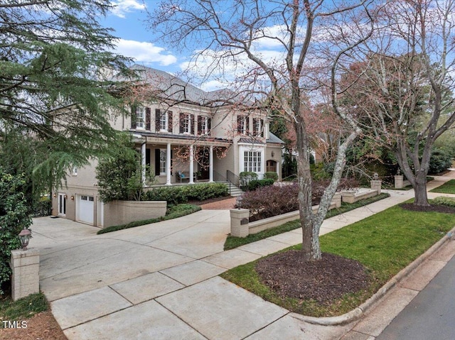 view of front of home with driveway, an attached garage, and a porch