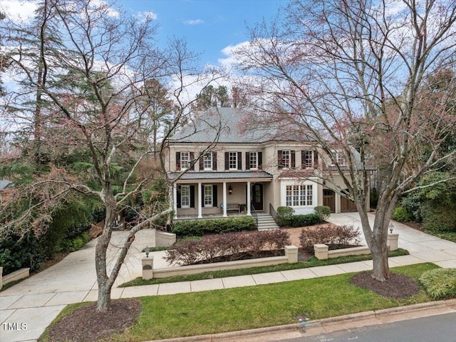 view of front of property featuring concrete driveway and a porch