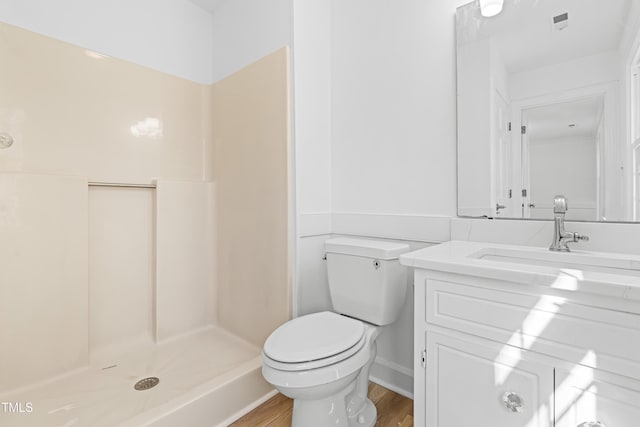 bathroom featuring hardwood / wood-style flooring, vanity, toilet, and walk in shower