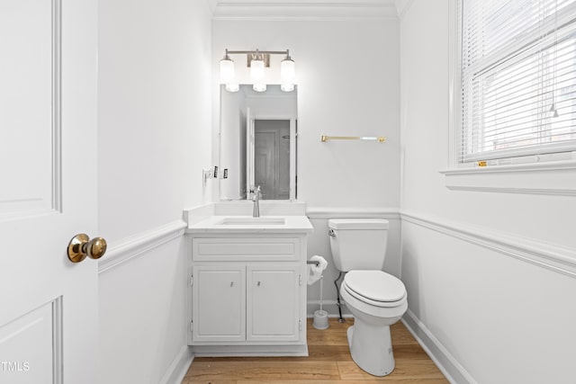 bathroom featuring ornamental molding, wood-type flooring, vanity, and toilet