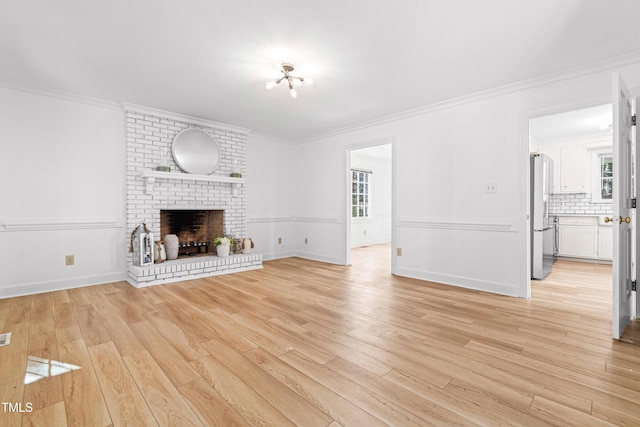 unfurnished living room with light hardwood / wood-style flooring, a fireplace, and ornamental molding