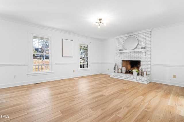 unfurnished living room with a fireplace, ornamental molding, and light hardwood / wood-style floors