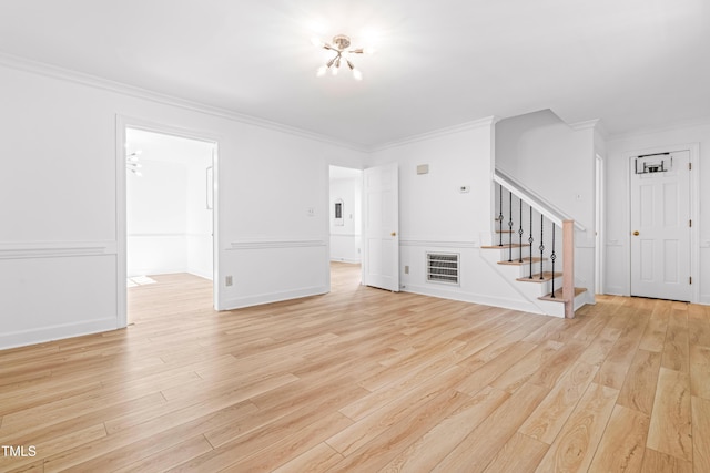 unfurnished living room with ornamental molding and light wood-type flooring