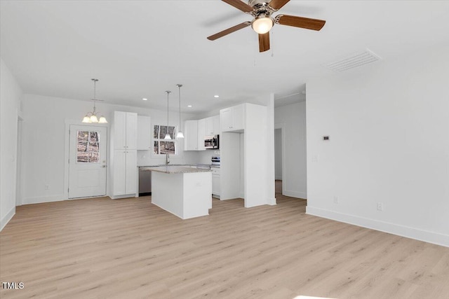 kitchen with a kitchen island, pendant lighting, white cabinets, and light wood-type flooring