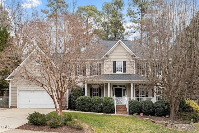 view of front of house featuring a garage, covered porch, and a front lawn