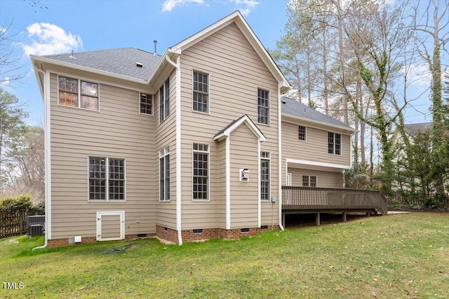 rear view of house featuring a wooden deck and a lawn