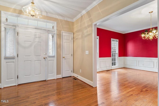 entryway featuring crown molding, a chandelier, and hardwood / wood-style floors