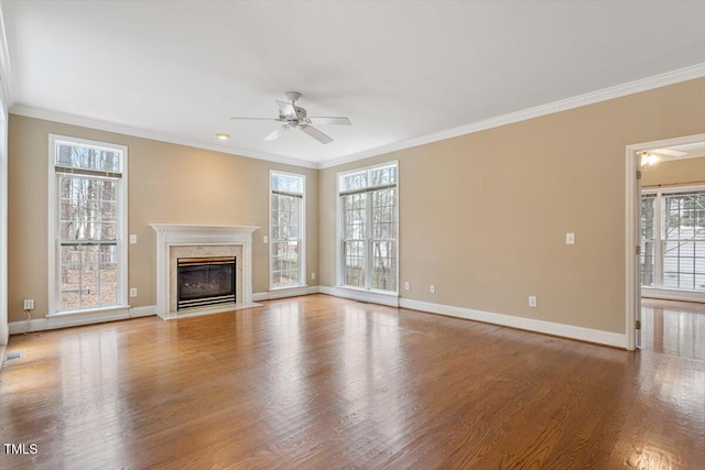 unfurnished living room with a fireplace, ornamental molding, ceiling fan, and light wood-type flooring