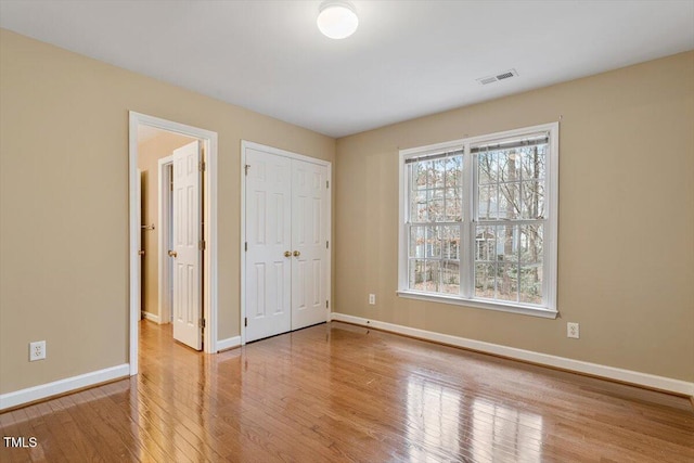 unfurnished bedroom with light hardwood / wood-style floors and a closet