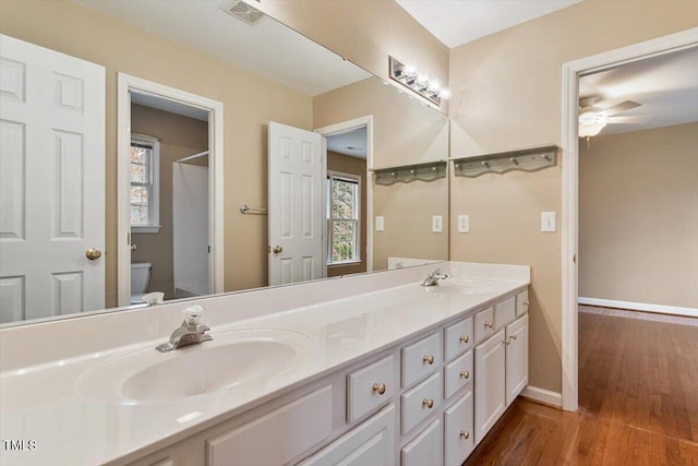 bathroom with vanity, wood-type flooring, toilet, and plenty of natural light