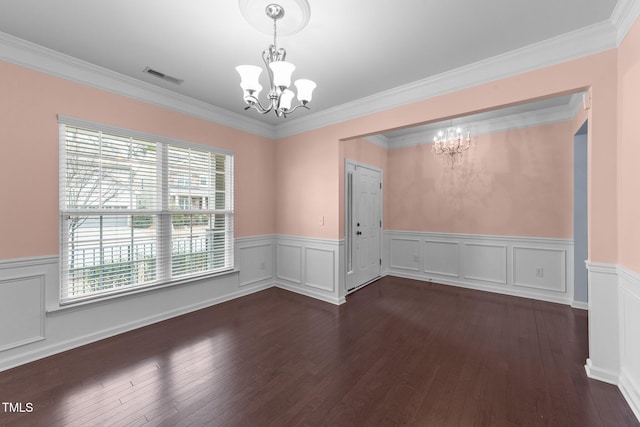 empty room featuring dark hardwood / wood-style floors, a wealth of natural light, and a notable chandelier