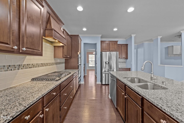 kitchen with sink, crown molding, dark hardwood / wood-style floors, stainless steel appliances, and light stone countertops